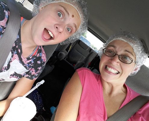 VernonHillsLice Two happy girls in the car with shower caps from lice treatment
