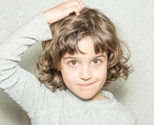 Girl itching her head because she has lice