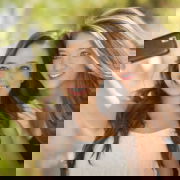 Two Attractive Mixed Race Girlfriends Taking Self Portrait with Their Phone Camera Outdoors. Two girls taking a selfie and smiling